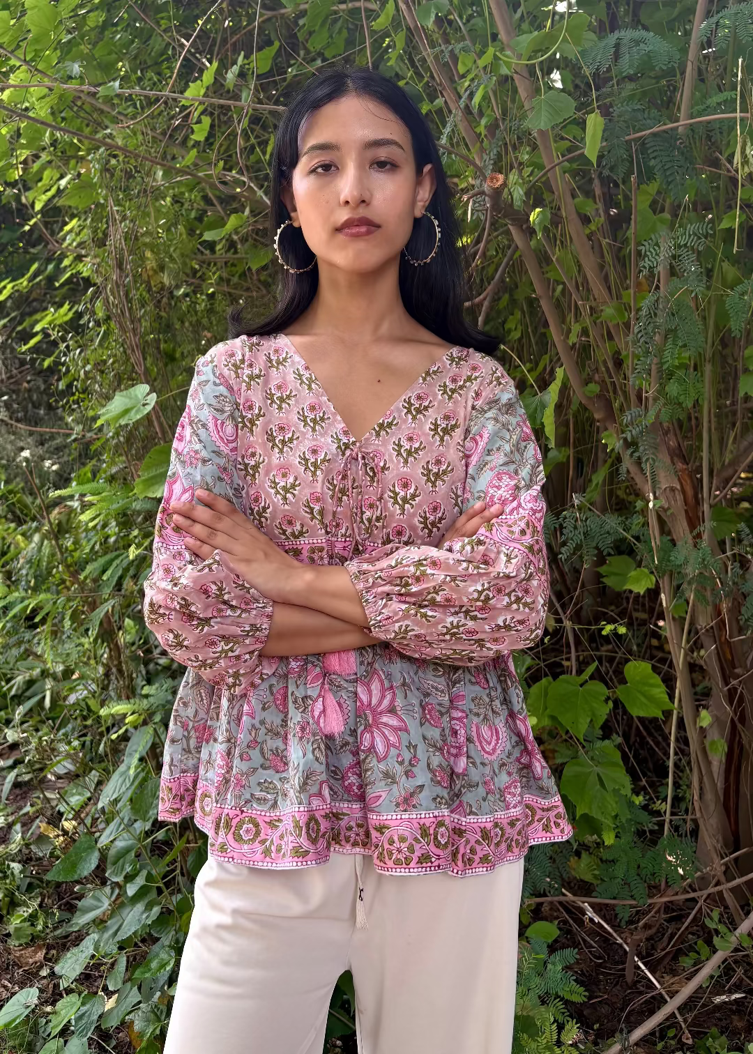 Woman wearing a Meher Peplum floral Printed Top That Romeo standing in a garden