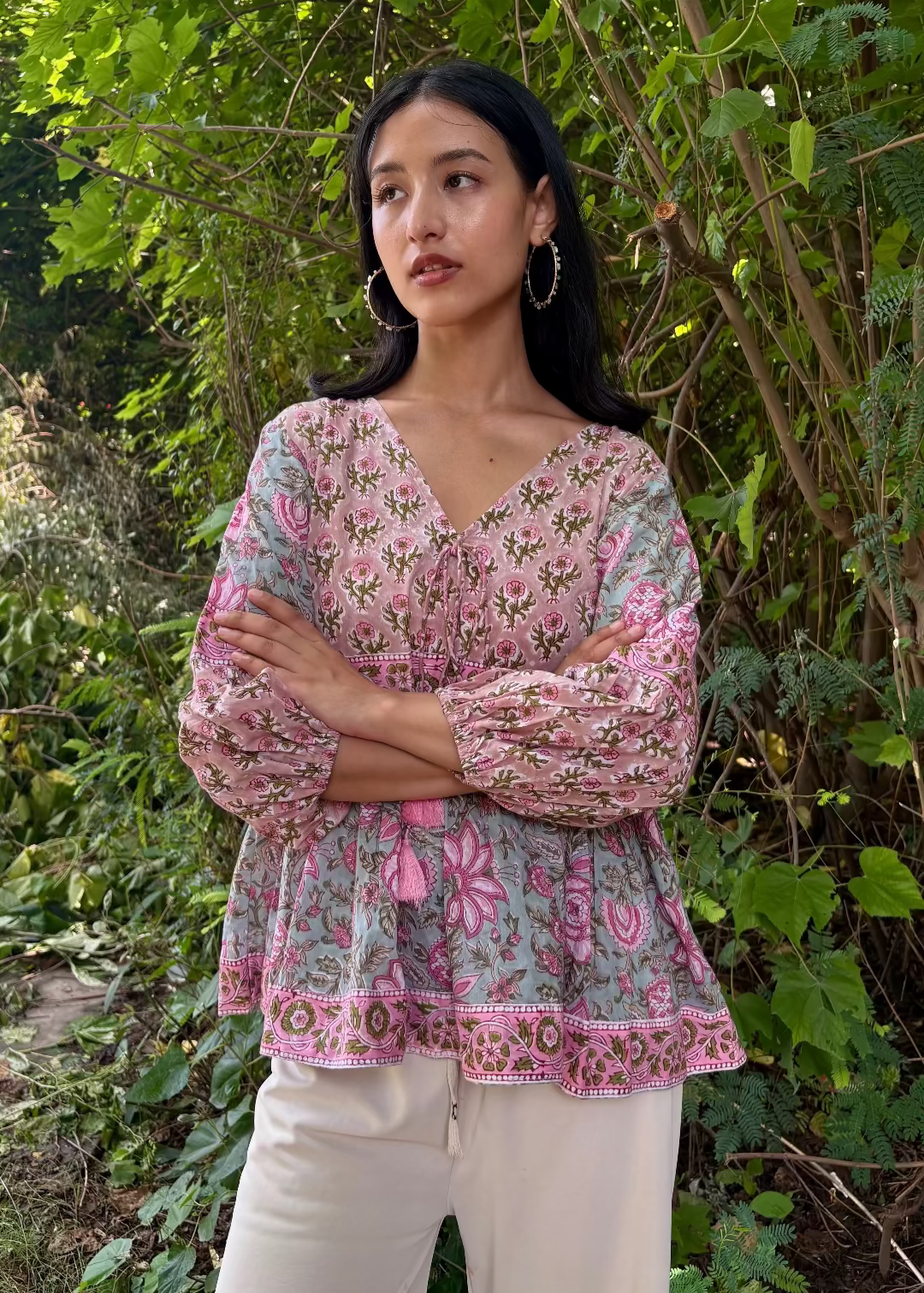 Woman wearing a Meher Peplum floral Printed Top That Romeo standing in a garden