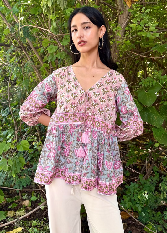 Woman wearing a Meher Peplum floral Printed Top That Romeo standing in a garden