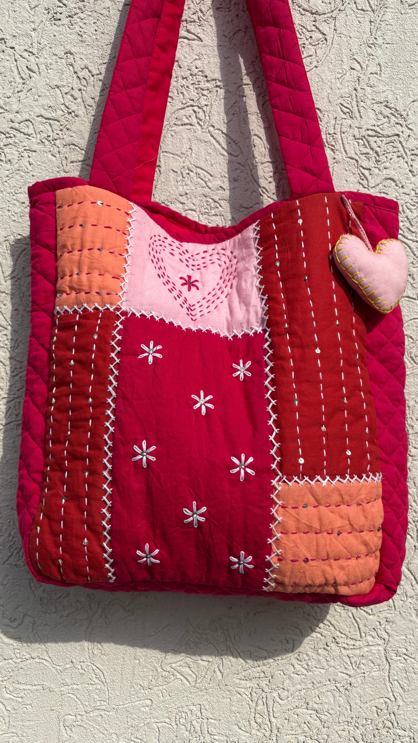 That Romeo handmade quilted tote in blush, rust, and red tones with Kantha heart embroidery, patchwork design, and heart charm — sustainable and artisanal