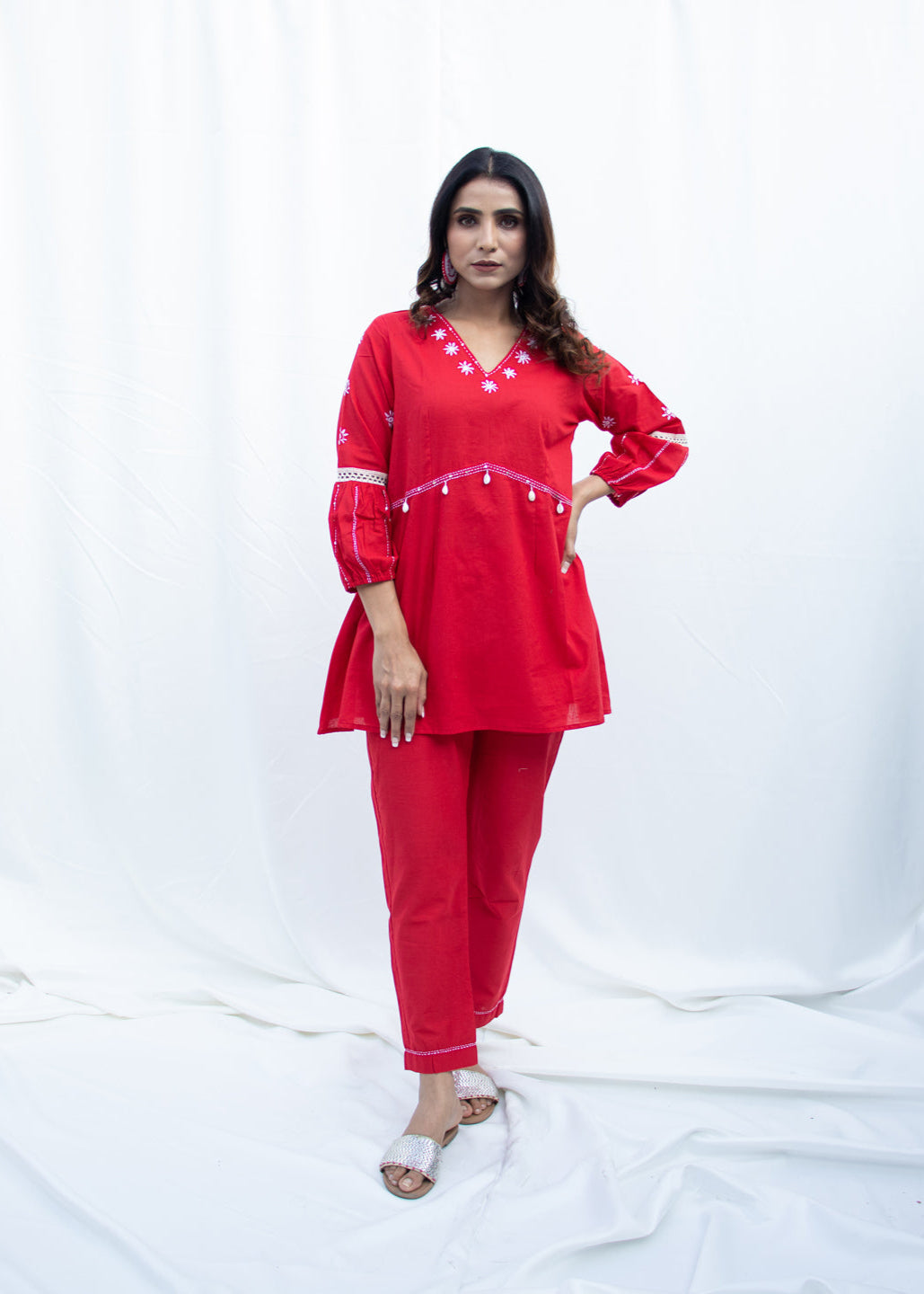 Model wearing the MINA ruby red cotton co-ord set with white Katha embroidery, lace trims, and kodi tassels – a bold, handcrafted outfit from That Romeo’s PARDESI Collection.