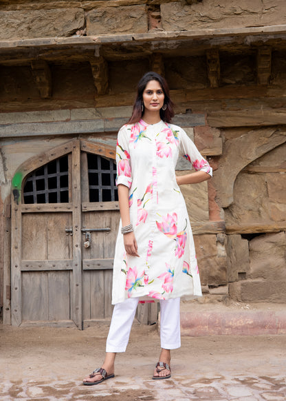 Model in ivory chanderi silk kurta with blooming pink lotus print and white trousers, standing against a rustic heritage wall.