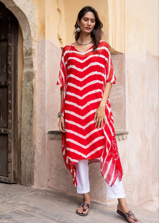 Model wearing the Gulamohar cherry red chiffon Leheriya kaftan with an asymmetrical hemline and inner slip – a festive essential from That Romeo’s Rangisaa Collection.