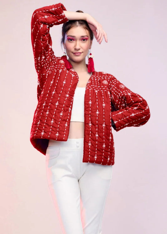 Model wearing a red hand-quilted cotton jacket with white star embroidery from the Silver Lining collection, styled with white pants and crop top.