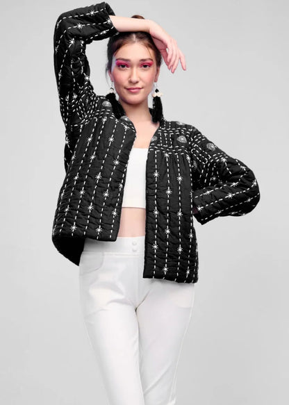 Model wearing a black hand-quilted jacket with white Katha embroidery, paired with a white crop top and trousers, showcasing the Zayla jacket's celestial design.