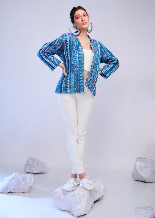 Model wearing a blue Katha embroidered jacket with white inner and pants, styled in a soft studio setting.