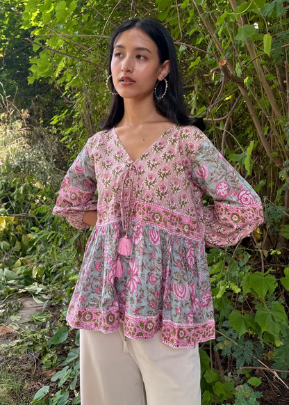 Woman wearing a Meher Peplum floral Printed Top That Romeo standing in a garden