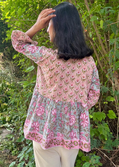 Woman wearing a Meher Peplum floral Printed Top That Romeo standing in a garden