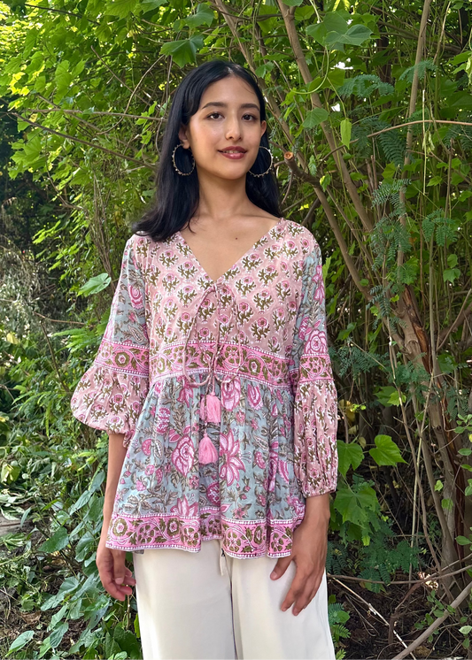 Woman wearing a Meher Peplum floral Printed Top That Romeo standing in a garden