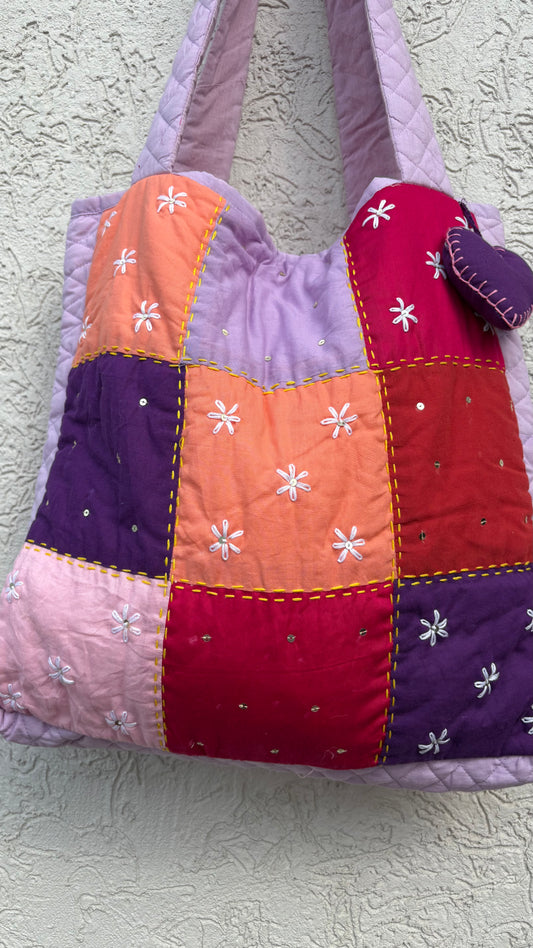 That Romeo handmade tote in lilac, peach, red, and violet with floral Kantha embroidery and a heart charm — quilted, upcycled, and artisan-crafted