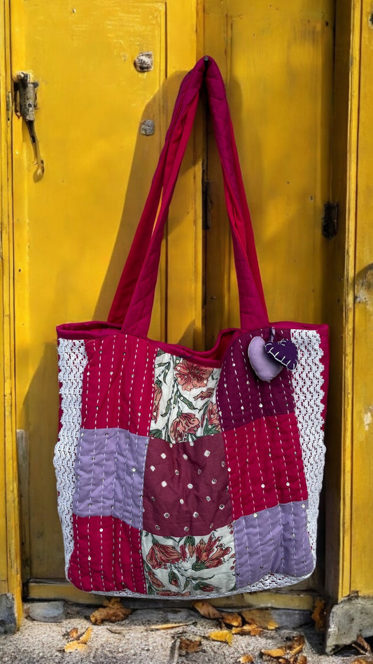 Handmade tote bag with floral center patch, Kantha stitching, lace sides, and quilted fabric in wine and lilac — sustainable and artisan-made by That Romeo