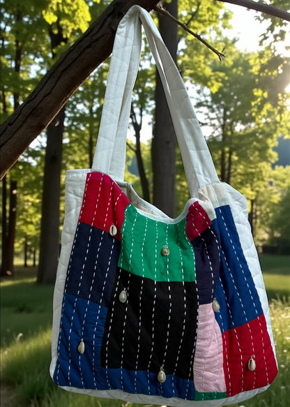 Handcrafted patchwork quilted tote bag by that romeo in multicolor cotton with kantha stitches and cowrie shells.