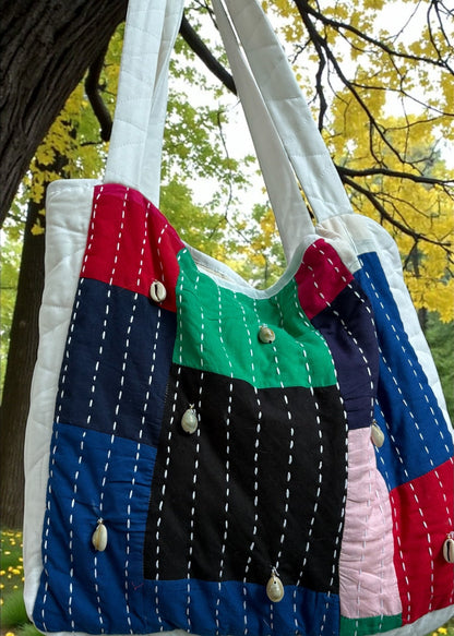 Handcrafted patchwork quilted tote bag by that romeo in multicolor cotton with kantha stitches and cowrie shells.