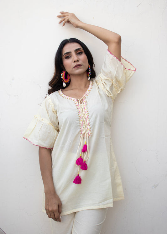 Model wearing the MIWA ivory cotton co-ord set featuring pink tassel tie-up neckline and handcrafted Katha embroidery – an elegant and sustainable outfit from That Romeo.