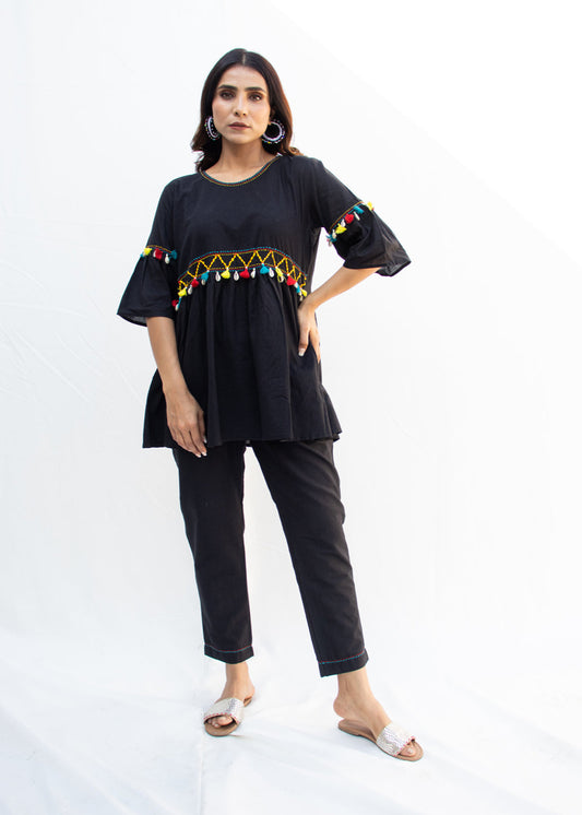 Model wearing the NYAH black cotton co-ord set with handcrafted Katha embroidery, dori work, and vibrant kodi tassels – a chic and sustainable design from That Romeo’s PARDESI Collection.