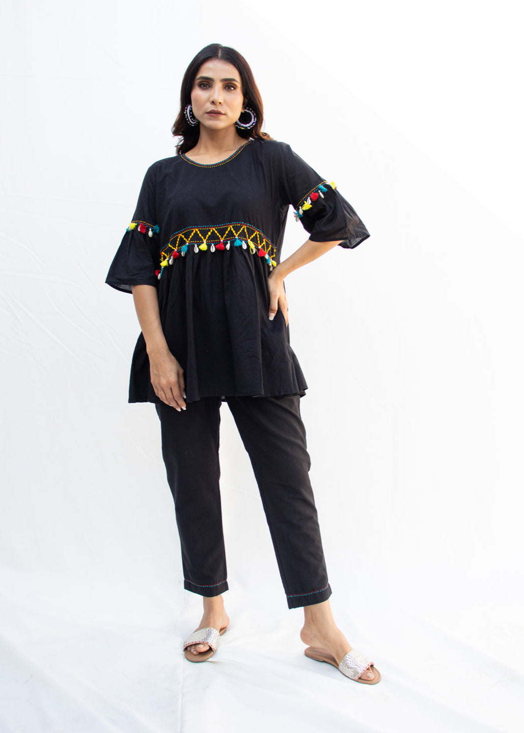 Model wearing the NYAH black cotton co-ord set with handcrafted Katha embroidery, dori work, and vibrant kodi tassels – a chic and sustainable design from That Romeo’s PARDESI Collection.