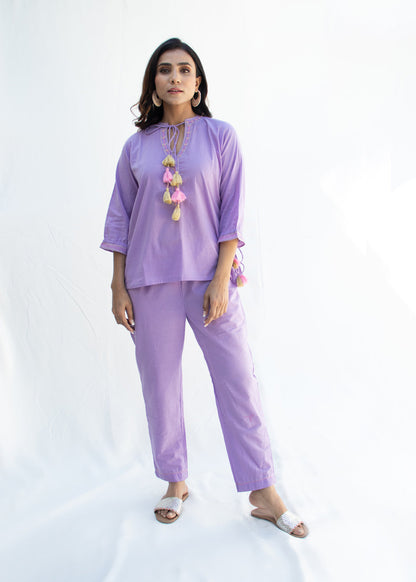Model wearing the AMINAAHA lavender cotton co-ord set with tassel tie-up neckline and delicate Katha embroidery – a pastel-toned, artisan-crafted outfit from That Romeo’s PARDESI Collection.