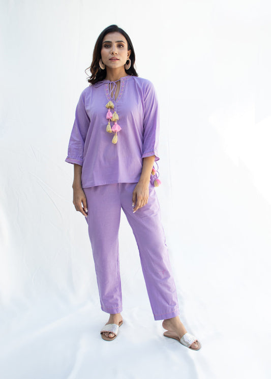 Model wearing the AMINAAHA lavender cotton co-ord set with tassel tie-up neckline and delicate Katha embroidery – a pastel-toned, artisan-crafted outfit from That Romeo’s PARDESI Collection.
