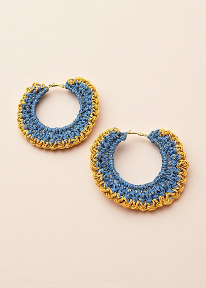 Blue crochet hoop earrings with gold chain detailing by ThatRomeo on a cream background.