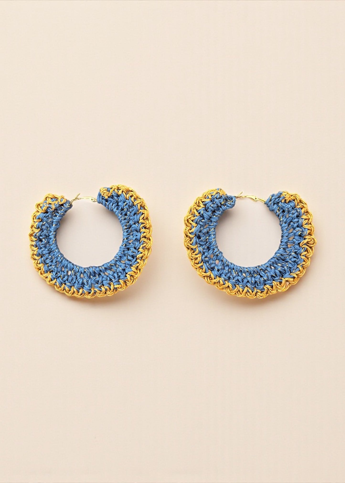 Blue crochet hoop earrings with gold chain detailing by ThatRomeo on a cream background.