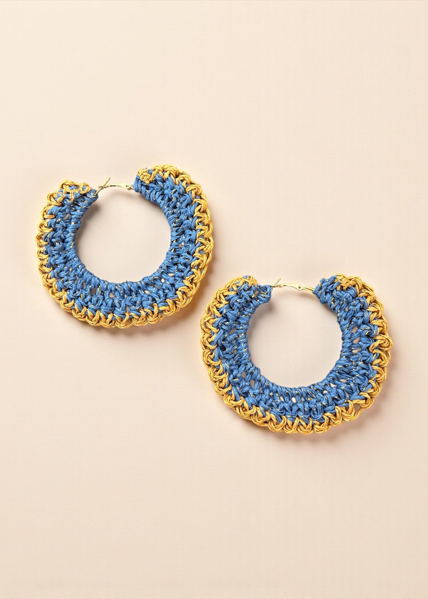Blue crochet hoop earrings with gold chain detailing by ThatRomeo on a cream background.