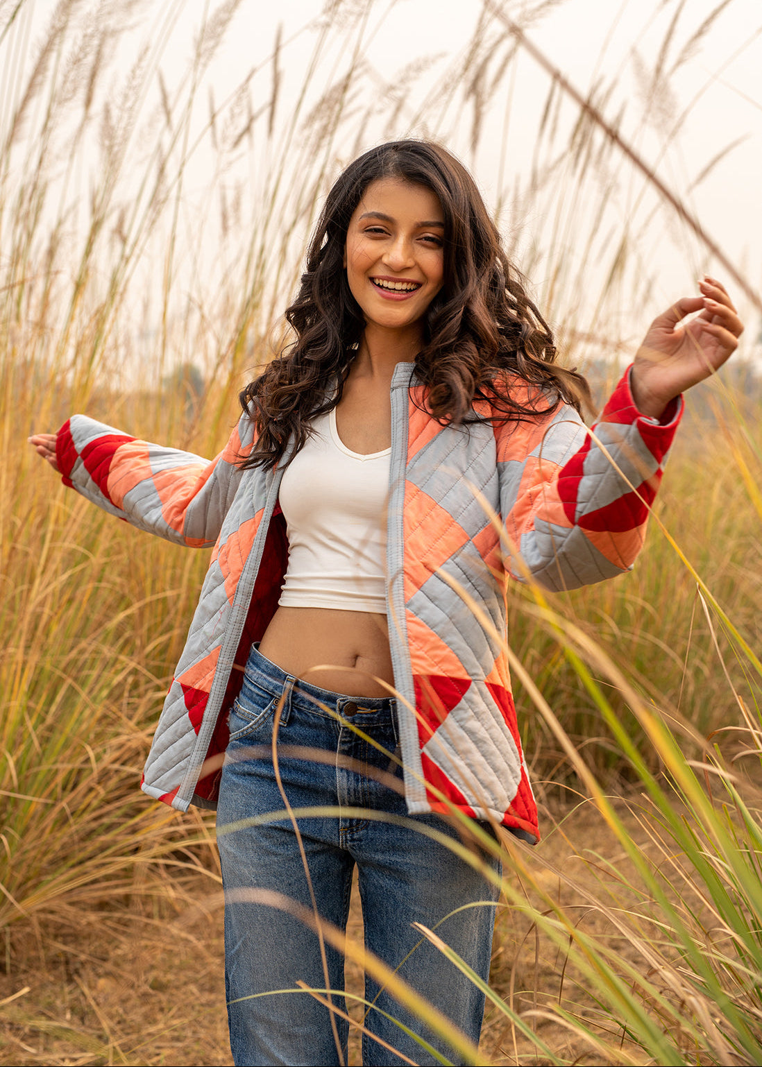 Model wearing ThatRomeo’s Boxy Patchwork Jacket — geometric quilted cotton jacket in coral, grey, and red tones.