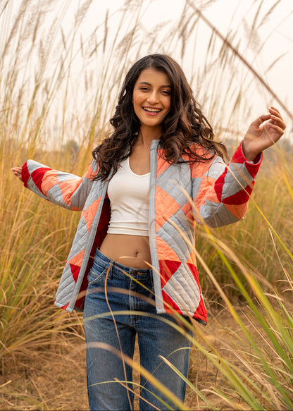 Model wearing ThatRomeo’s Boxy Patchwork Jacket — geometric quilted cotton jacket in coral, grey, and red tones.