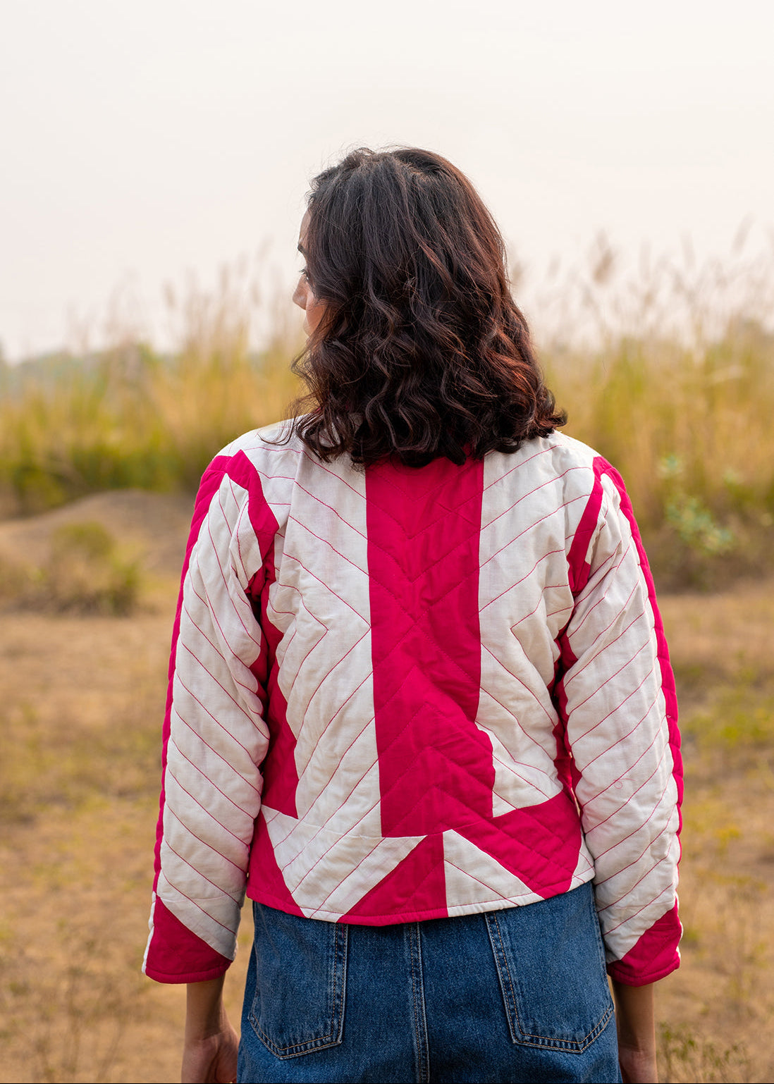 Model wearing ThatRomeo’s Candy Bolt Quilted Jacket — fuchsia and ivory cotton jacket with geometric pattern and open front.