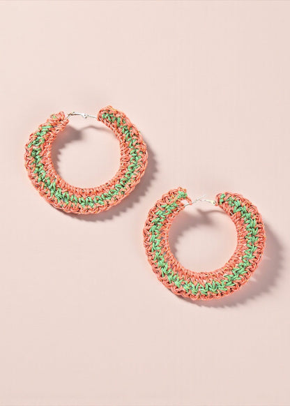 Coral and green crochet hoop earrings by ThatRomeo on a soft pink background.