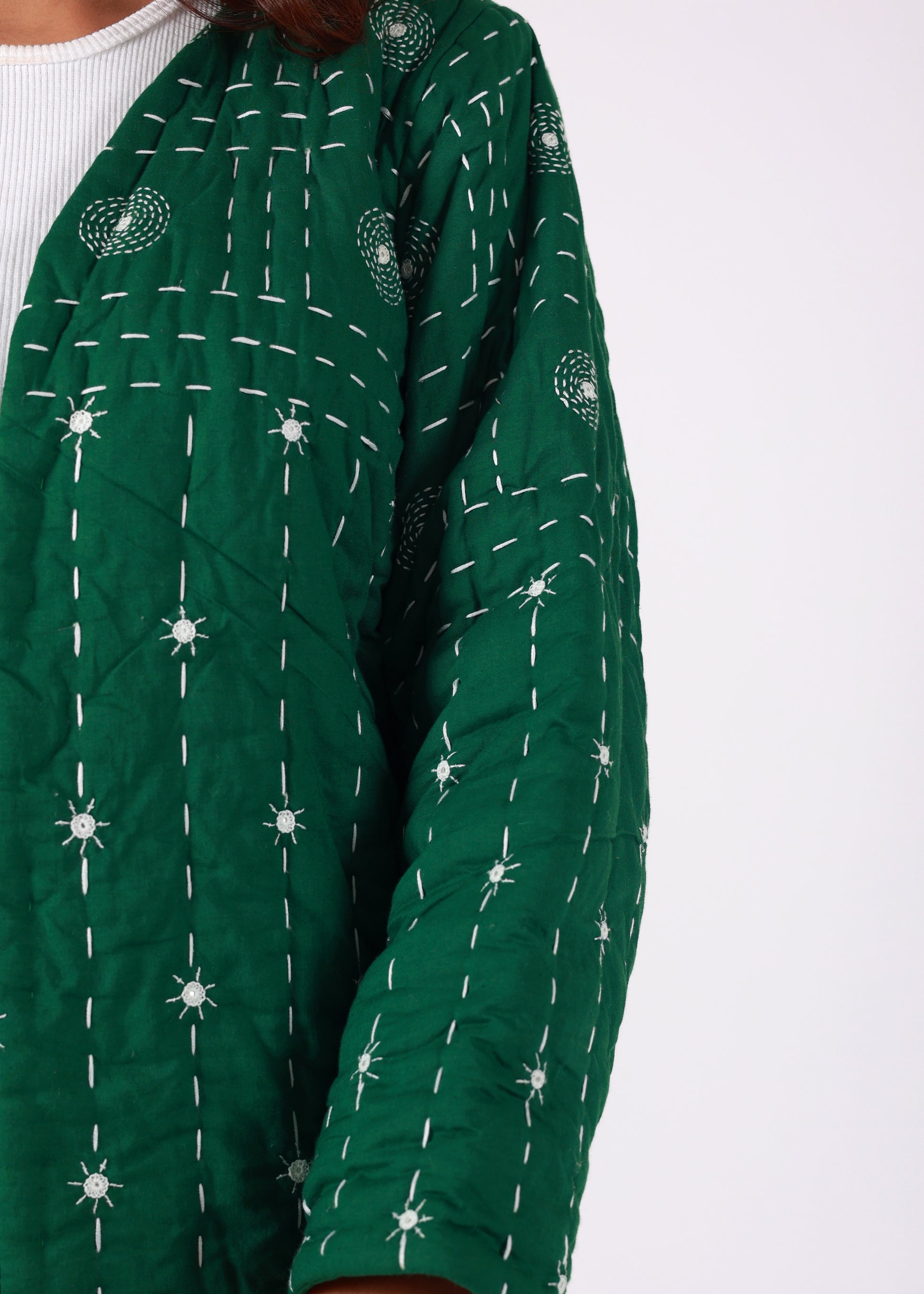 Model wearing ThatRomeo’s Emerald Echo Quilted Jacket — emerald green cotton jacket with white thread embroidery and open front.