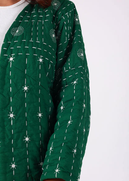 Model wearing ThatRomeo’s Emerald Echo Quilted Jacket — emerald green cotton jacket with white thread embroidery and open front.