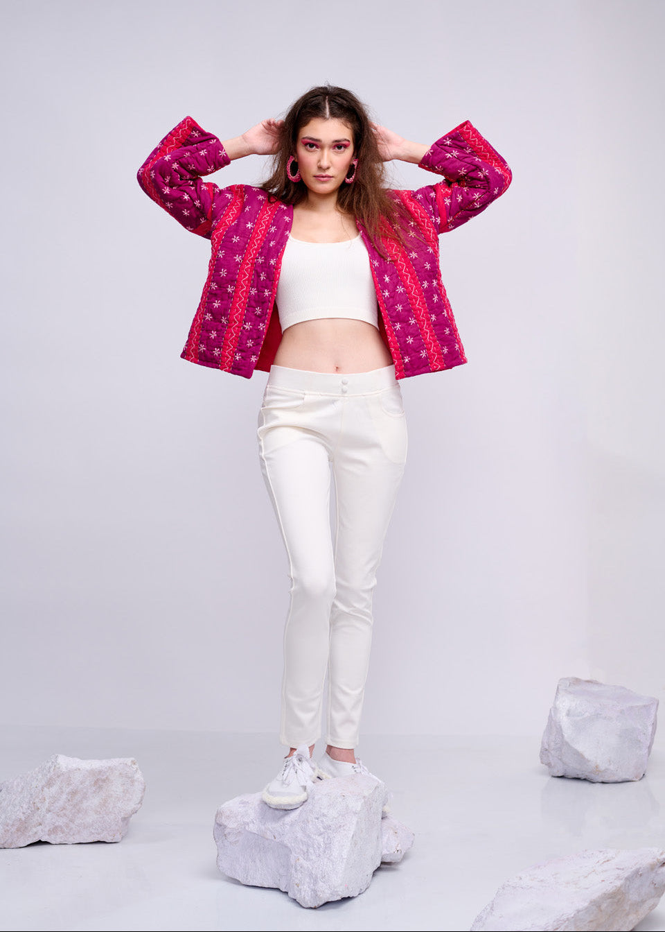 Model wearing ThatRomeo’s Fuchsia Bloom Quilted Jacket — bright fuchsia cotton jacket with white embroidery, styled with white pants.