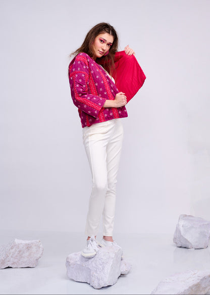 Model wearing ThatRomeo’s Fuchsia Bloom Quilted Jacket — bright fuchsia cotton jacket with white embroidery, styled with white pants.