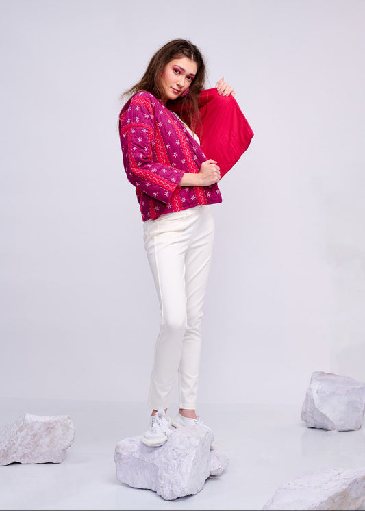 Model wearing ThatRomeo’s Fuchsia Bloom Quilted Jacket — bright fuchsia cotton jacket with white embroidery, styled with white pants.