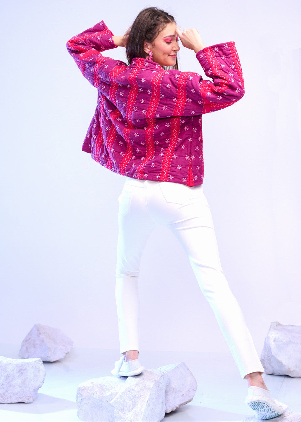 Model wearing ThatRomeo’s Fuchsia Bloom Quilted Jacket — bright fuchsia cotton jacket with white embroidery, styled with white pants.