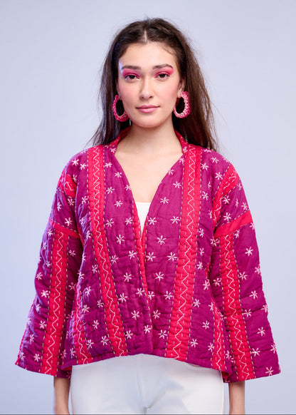 Model wearing ThatRomeo’s Fuchsia Bloom Quilted Jacket — bright fuchsia cotton jacket with white embroidery, styled with white pants.