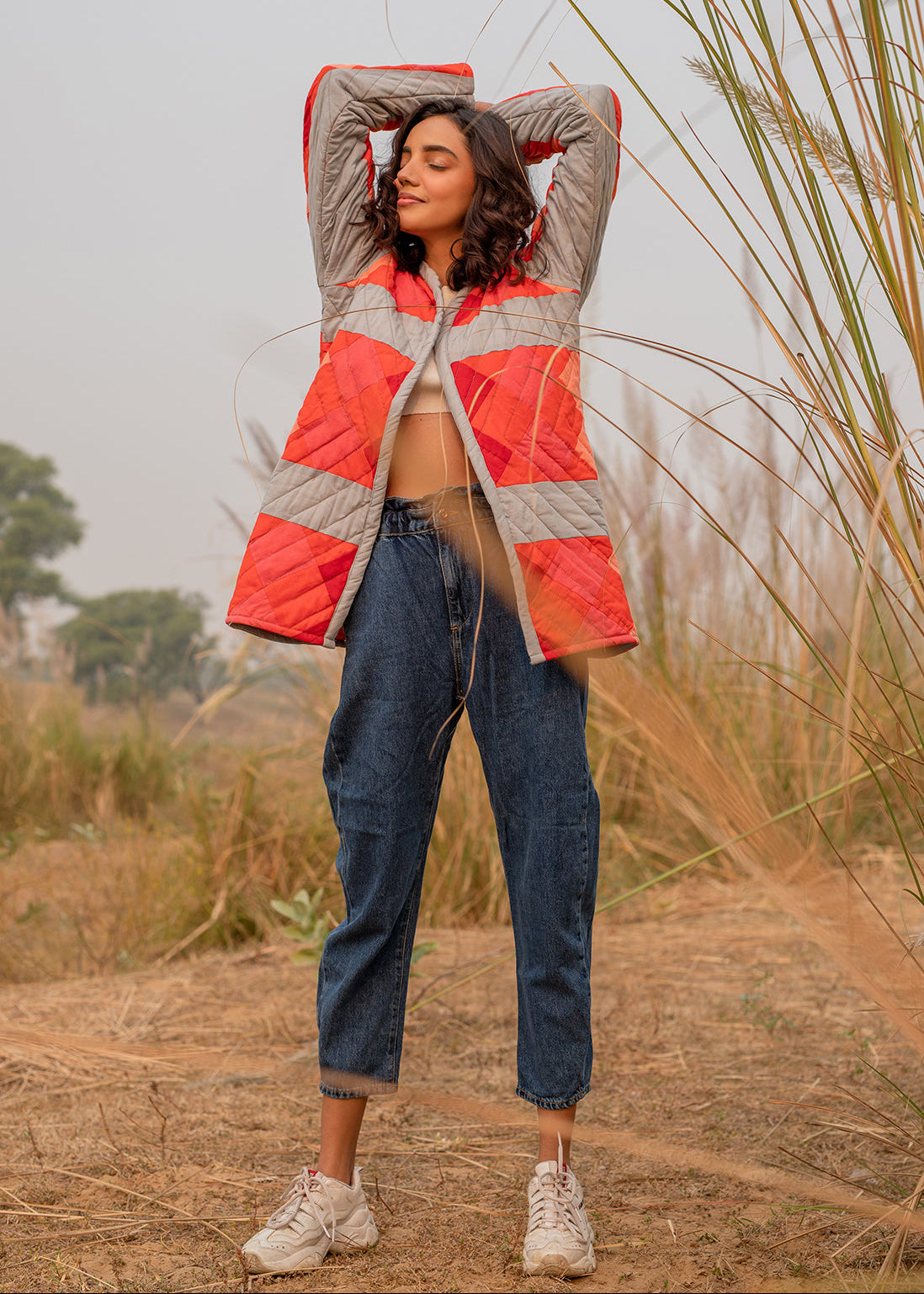 Model wearing ThatRomeo’s Maple Squarzy Patchwork Jacket — grey and red geometric quilted jacket in longline silhouette.