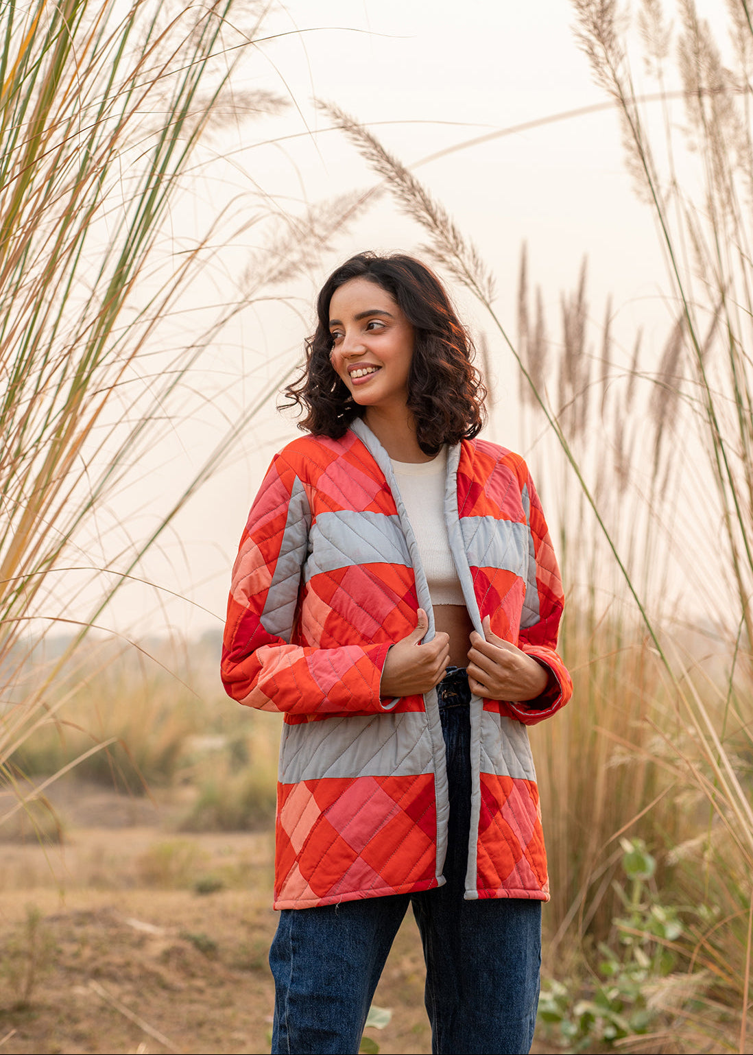 Model wearing ThatRomeo’s Maple Squarzy Patchwork Jacket — grey and red geometric quilted jacket in longline silhouette.