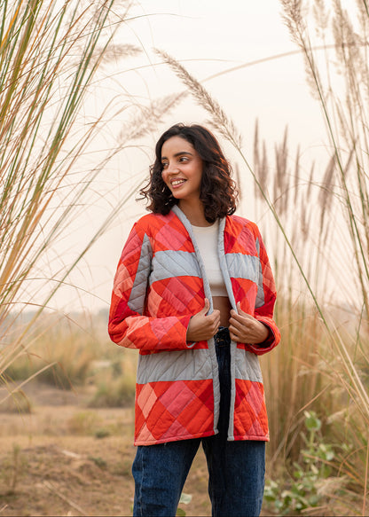 Model wearing ThatRomeo’s Maple Squarzy Patchwork Jacket — grey and red geometric quilted jacket in longline silhouette.