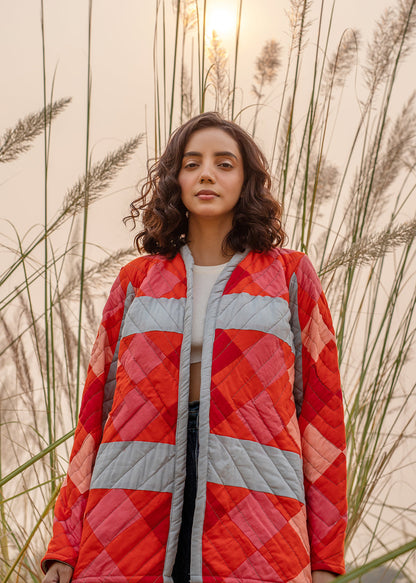 Model wearing ThatRomeo’s Maple Squarzy Patchwork Jacket — grey and red geometric quilted jacket in longline silhouette.