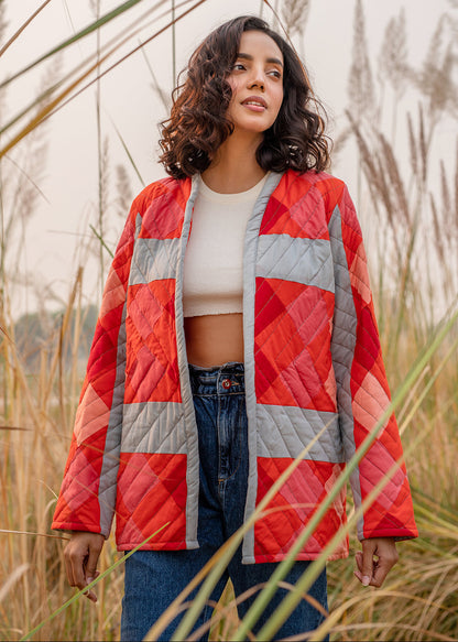 Model wearing ThatRomeo’s Maple Squarzy Patchwork Jacket — grey and red geometric quilted jacket in longline silhouette.