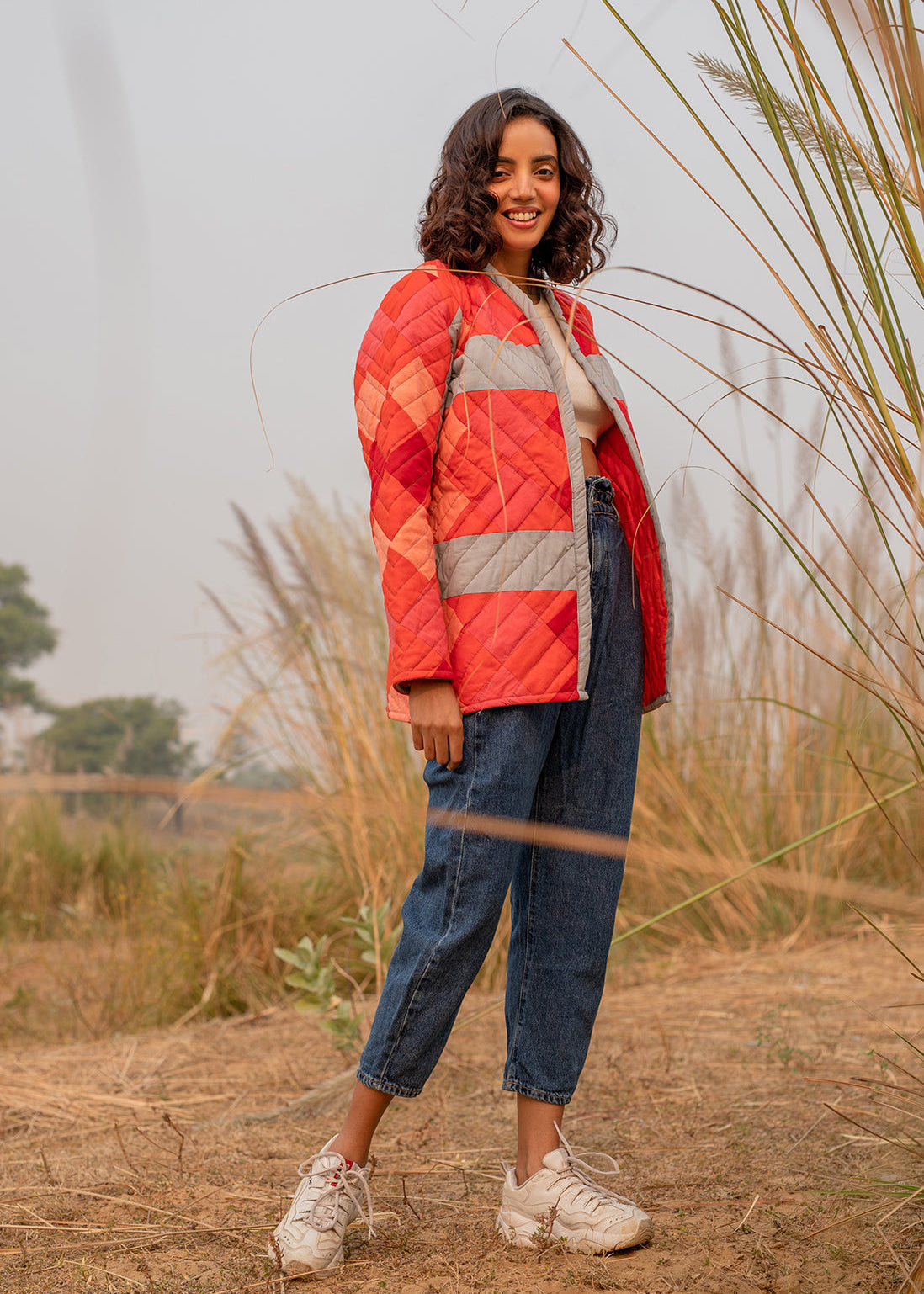 Model wearing ThatRomeo’s Maple Squarzy Patchwork Jacket — grey and red geometric quilted jacket in longline silhouette.