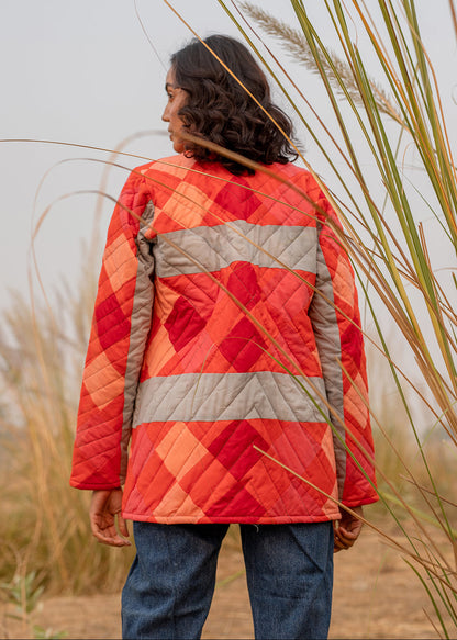 Model wearing ThatRomeo’s Maple Squarzy Patchwork Jacket — grey and red geometric quilted jacket in longline silhouette.