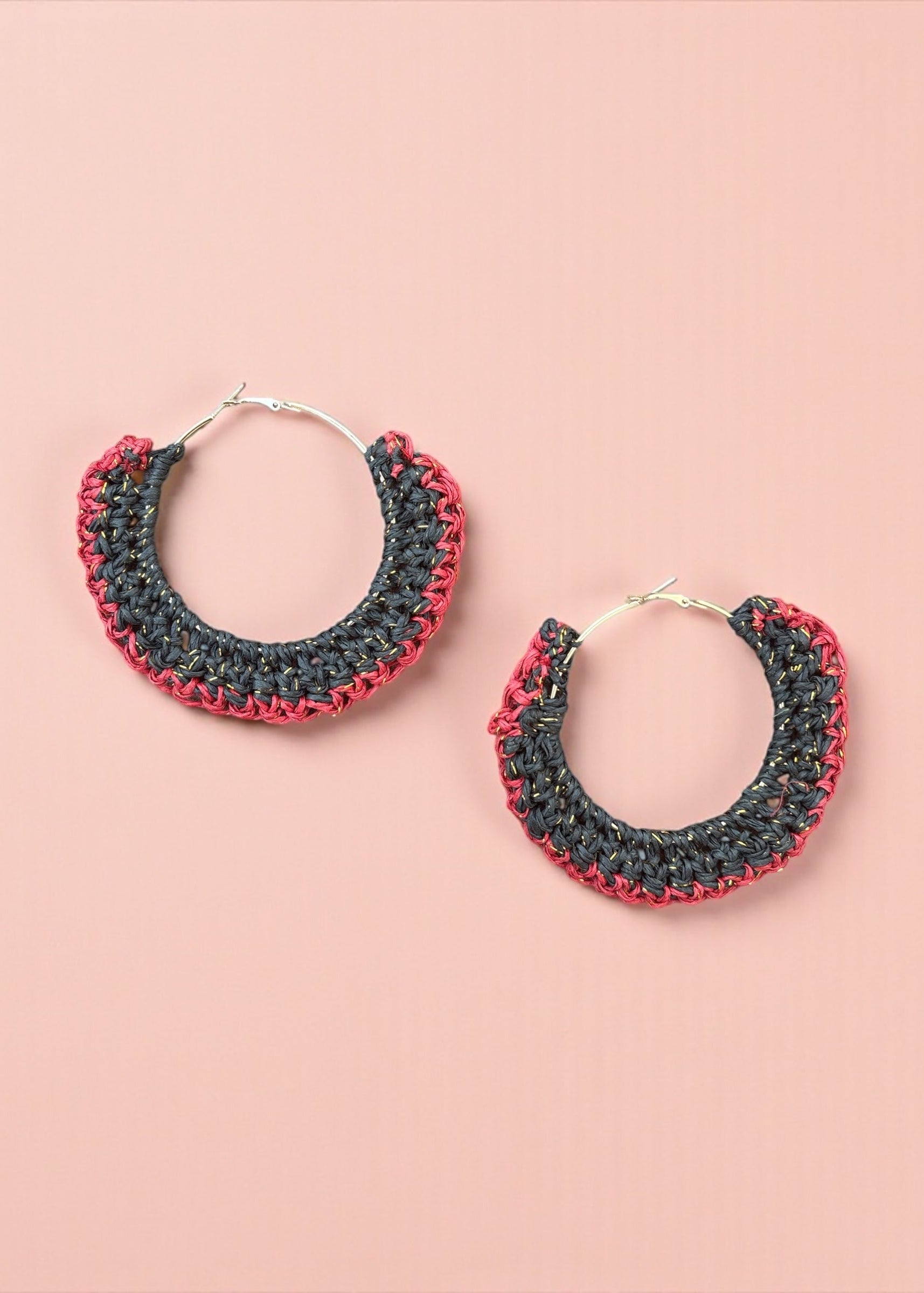 Charcoal black and red crochet hoop earrings by ThatRomeo on a blush background.