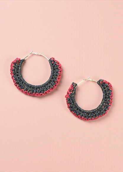 Charcoal black and red crochet hoop earrings by ThatRomeo on a blush background.