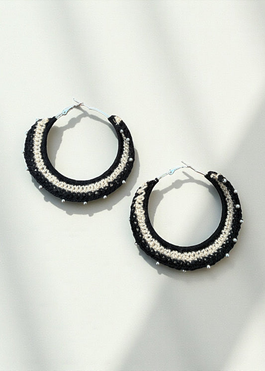 Black and cream crochet hoop earrings with bead accents by ThatRomeo on a soft-light background.