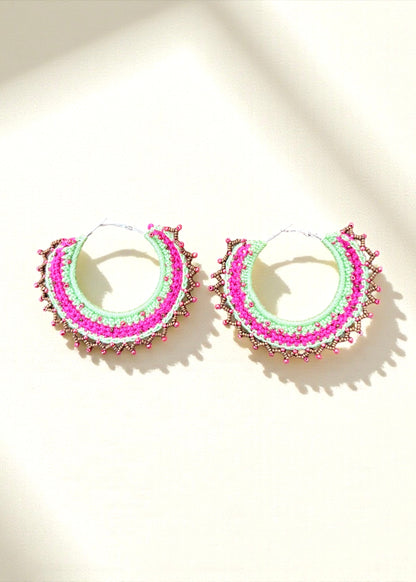 Neon green and hot pink crochet hoop earrings with gold and pink beads by ThatRomeo on a light background.