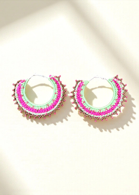 Neon green and hot pink crochet hoop earrings with gold and pink beads by ThatRomeo on a light background.