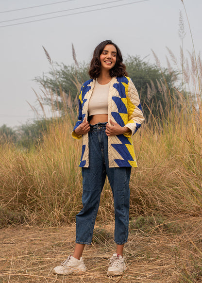Model wearing ThatRomeo’s Sky Circuit Quilted Jacket — cotton patchwork jacket in cobalt blue, yellow, and cream tones with open front.